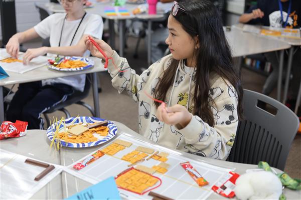 Delicious Design  Shaping her design, Ava uses food as elements of design. Yearbook staffers learn design principles like balance and proportion to ensure every page of the book is as visually appetizing as the subjects they photograph.