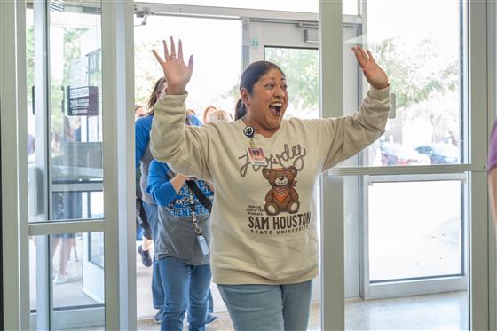 A group of women smiling and posing together in a cheerful setting.