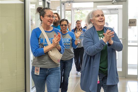 A group of women smiling and posing together in a cheerful setting.