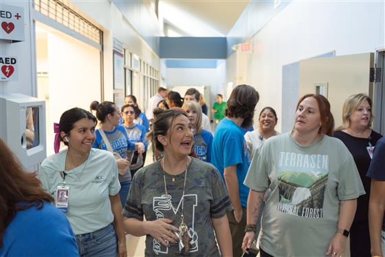 A group of women smiling and posing together in a cheerful setting.